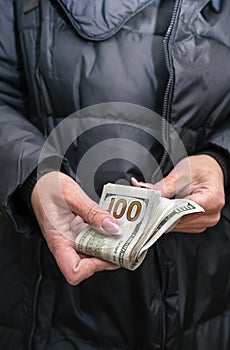 Selective focus.  A Wad of hundred dollar bills in female hand