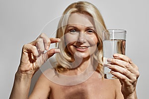 Selective focus of water and pill in woman hands photo