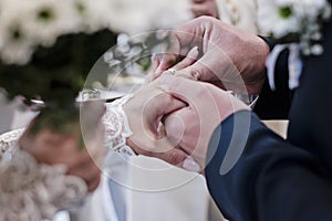 Selective focus on wedding ring. The bride and groom exchange rings during a wedding ceremony