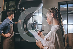 selective focus of woman checking colleagues work during coffee