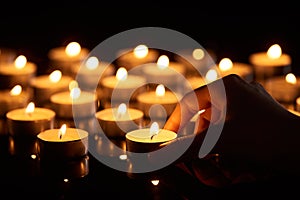 Selective focus of woman holding burning candle in darkness