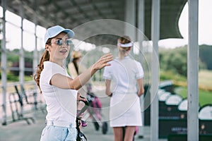 selective focus of woman in sunglasses with golf gear pointing away