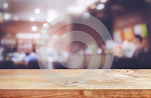 Selective focus.Wood table top with blur light bokeh in dark night cafe,restaurant background