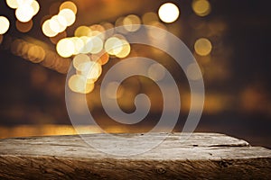 Selective focus.Wood table top with blur light bokeh in dark night cafe,restaurant background