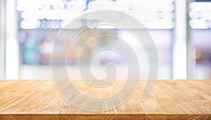 Selective focus of wood table top on blur product shelf in supermarket background