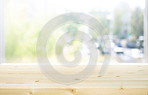 Selective focus.Wood table top on blur of window with garden background in morning.For montage product display or design key
