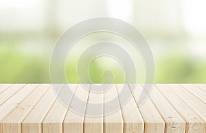 Selective focus.Wood table top on blur of window with garden flower background in morning