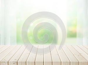 Selective focus.Wood table top on blur of window with garden flower background in morning