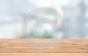 Selective focus of wood table top on white wall glass big window background