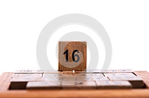 Selective focus. Wooden cube number 16 not used in the puzzle Game 15