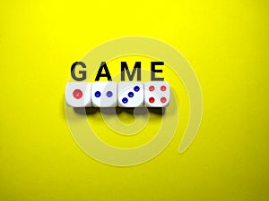 Selective focus.Word GAME with white dice on a yellow background.Shot were noise and film grain.