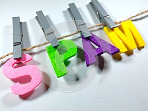 Selective focus.Word SPAM with clothespins on white background.