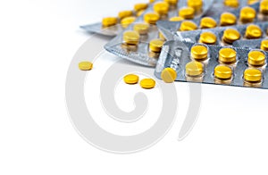 Selective focus on yellow tablets pill on blurred background of blister pack of round yellow pills. Diclofenac medicine