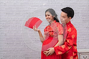 Selective focus young Asian couple newlywed hug together show red envelops angpao in Traditional Chinese New Year Festival Holiday