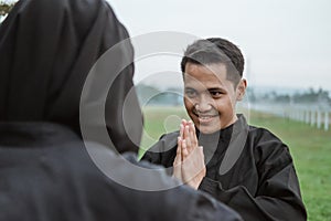 Selective focus of young Asian men wearing pencak silat uniforms with poses of respect for their opponents