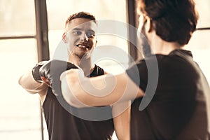 selective focus of young athletes in boxing gloves greeting each other