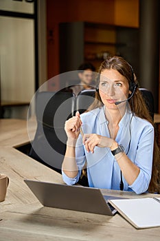 Selective focus of young female caucasian call center operator looking away