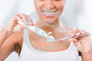 Selective focus of young woman putting toothpaste photo