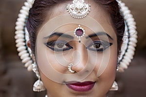 Selective focus of a young woman`s beautiful face in dancing costume. Indian Dancer