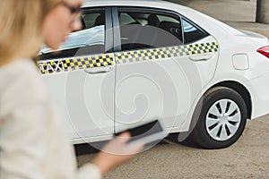 selective focus young woman using smartphone while standing