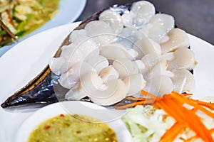 Selective Focused Thai Fresh Seafood: thinly sliced scallop sashimi with shell decoration, served with cabbage, carrot and spicy photo