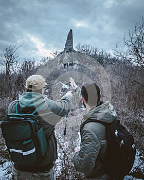 Selective fokus. Two men in the woods with a backpack, they found an unknown stone wall