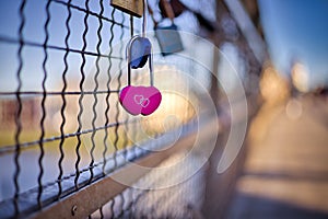 Selective shot of blue and pink heart-shaped love padlocks, locked to fence,concept of eternity love