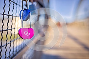 Selective shot of blue and pink heart-shaped love padlocks, locked to fence,concept of eternity love