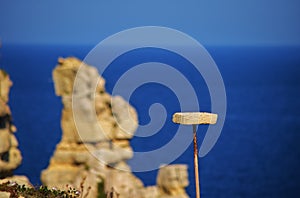 Selective shot of a perch for trapping songbirds, with Tal-Mara rock stack on the blue background