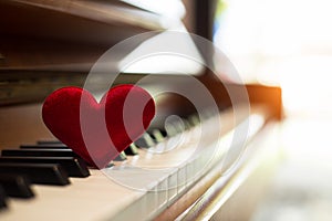 In selective of small red heart put on blurred piano,vintage warm light tone