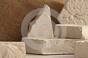 Selective soft focus. Empty eco stack of stones platform podium on beige and canvas background. Minimal empty display product