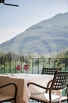 Selective of a table with wine glasses in a balcony facing the mountains