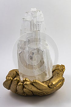 Selenite Tower in Golden hands. photo