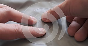 Self adhesive gray repair patch on inflatable air mattress. Close up details of male hands repairing a puncture in a sleeping mat