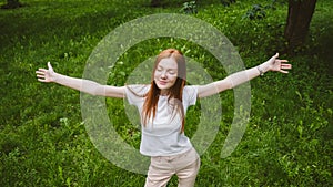 Self care, mental wellbeing, mental health, mindfulness. Young red-haired woman enjoying life in nature among flowers