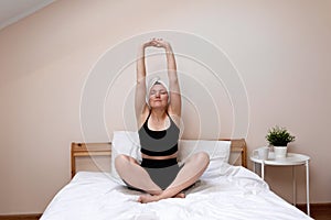 Self care and wellbeing concept, healthy morning routing, lifestyle. Serene adult woman with towel turban on head exercising yoga