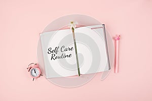 Self Care, wellbeing Routine, holistic set of self-care activities concept with open notebook, flower narcissus and alarm clock on photo