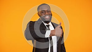 Self-confident afro-american businessman making thumbs-up gesture, good service