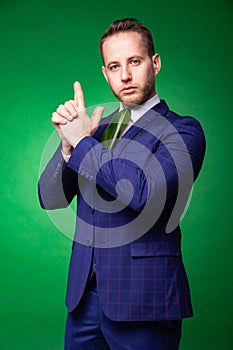 Self confident businessman in green leaf tie pointing at camera