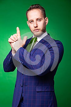 Self confident businessman in green leaf tie pointing at camera