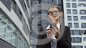Self-confident businesswoman texting on phone