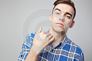 Self Confident guy dressed in a plaid shirt is on a white background in the studio photo