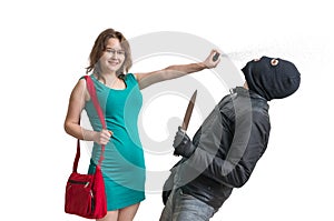 Self defense concept. Young woman is defending herself with pepper spray. photo