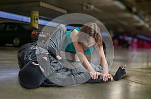 Self defense concept. Young woman is fighting with mugger or thief photo