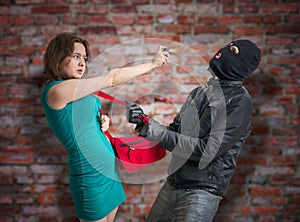 Self defense concept. Young woman is fighting with thief and using pepper spray