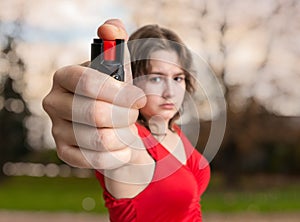 Self-defense concept. Young woman holds pepper spray in hand