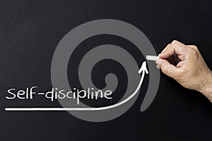 Self discipline concept. Hand with chalk drawing rising arrow. Discipline and self motivation.