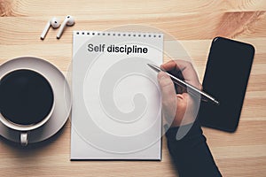 Self discipline - text on notepad, female hand with pen ready to write list to do