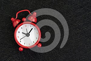 Self discipline, time, deadline and meeting schedule background with cute red alarm clock on dark black background with texture