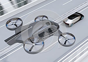 Self-driving Passenger Drone Taxi flying over an autonomous electric car driving on the highway